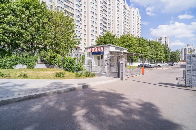 Въезд на охраняемую территорию сервиса через шлагбаум, рядом автомойка